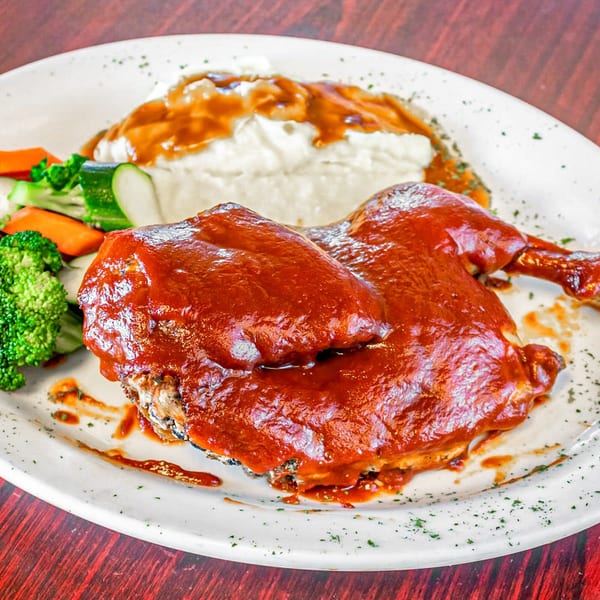 BBQ chicken leg and thigh with mashed potatoes and gravy, broccoli, carrots, and zucchini.